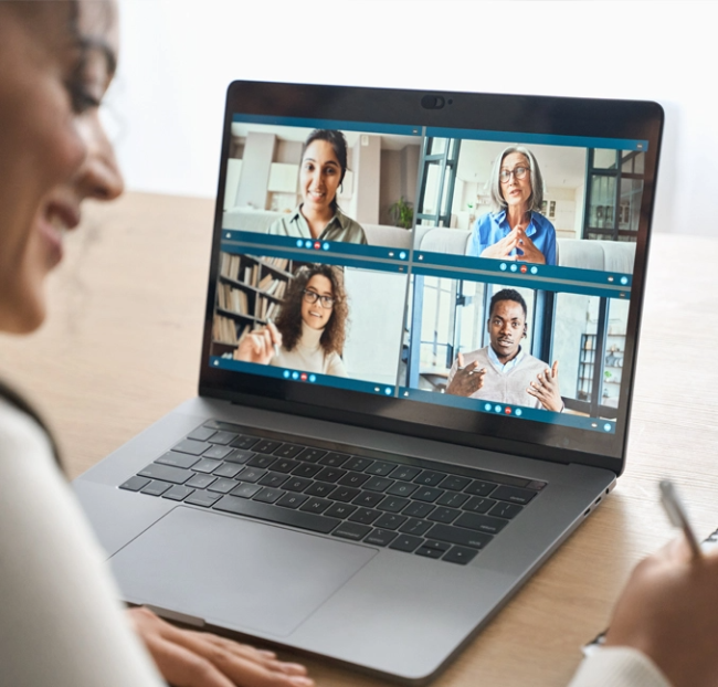 Woman sitting in front of a laptop participating in a virtual meeting